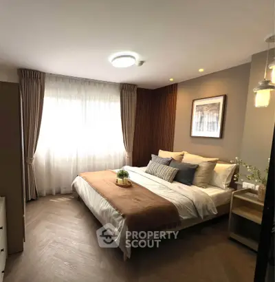 Elegant bedroom with cozy decor and natural light, featuring stylish curtains and modern lighting.