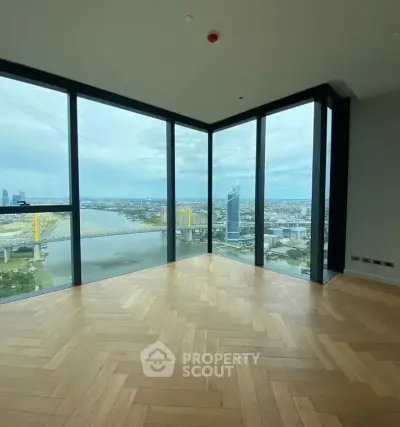Stunning corner unit with panoramic city and river views, featuring floor-to-ceiling windows and elegant herringbone flooring.