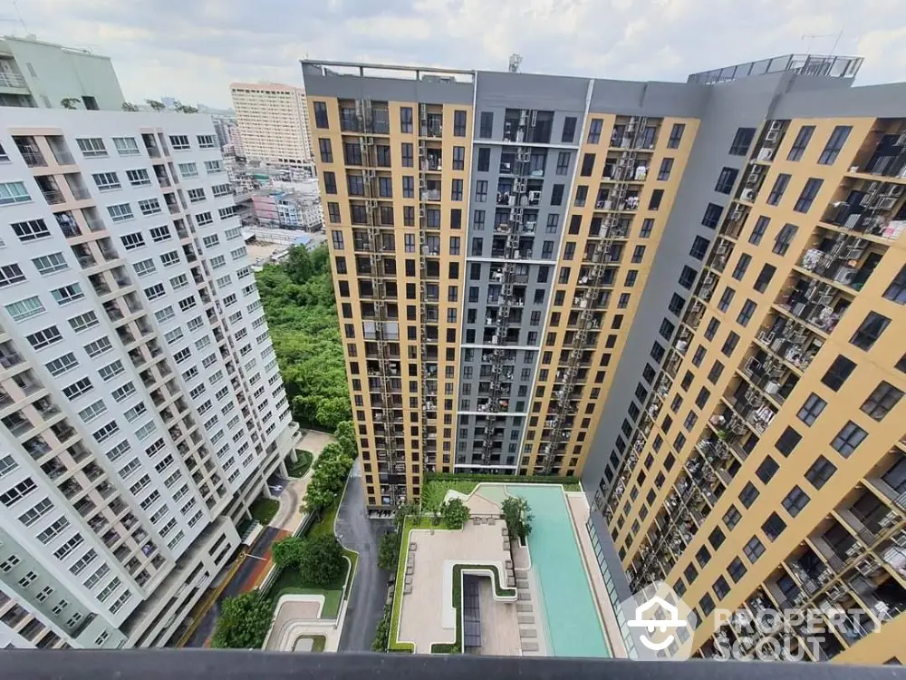 Stunning aerial view of modern high-rise apartment buildings with a luxurious pool area.