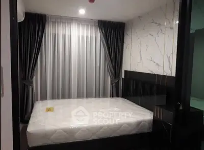 Modern bedroom with elegant curtains and marble accent wall in a stylish apartment.