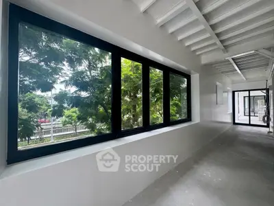 Spacious corridor with large windows offering lush green views