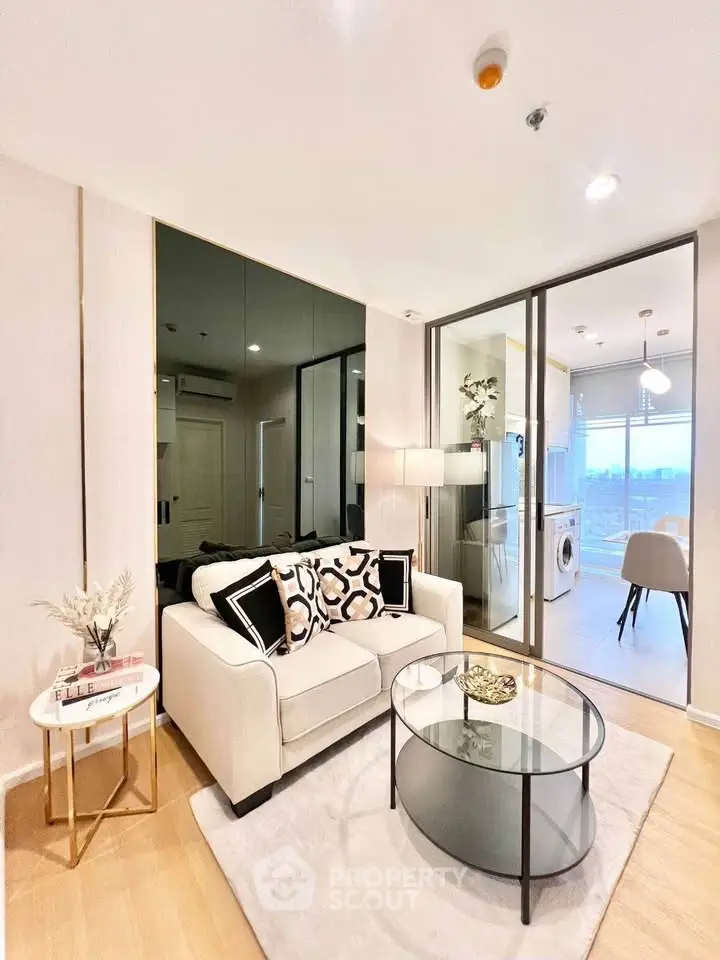 Modern living room with glass partition, cozy sofa, and stylish decor in a bright apartment.