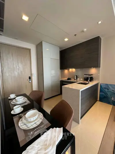 Modern kitchen with sleek cabinetry and dining area in a stylish apartment