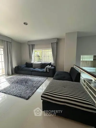 Spacious living room with modern furniture and large windows offering natural light.