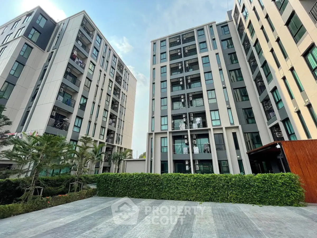 Modern apartment buildings with lush greenery and spacious courtyard.