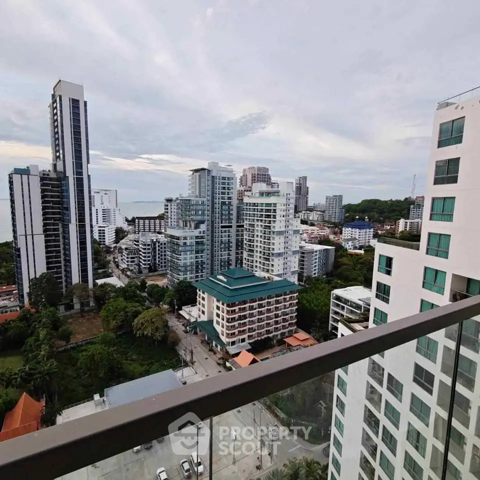 Stunning high-rise cityscape view from a modern balcony overlooking urban skyline and distant ocean.