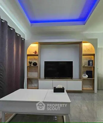 Modern living room with stylish ceiling lights and sleek entertainment center.