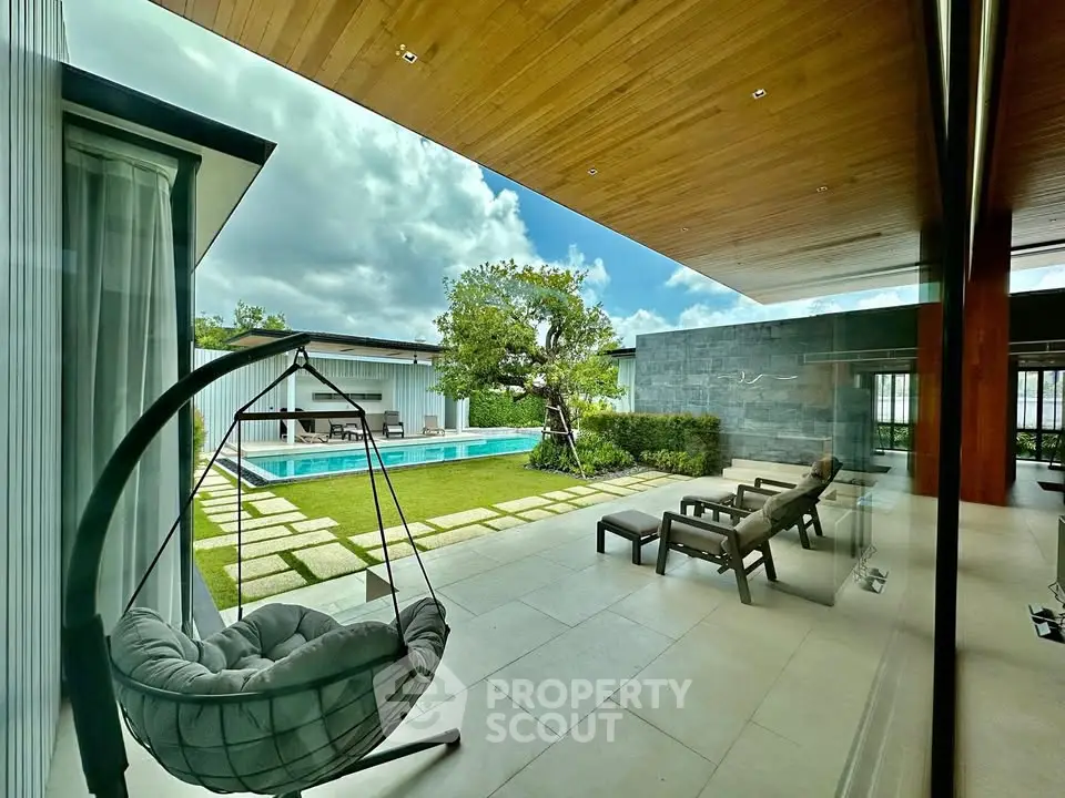 Luxurious modern patio with pool view and stylish outdoor seating, perfect for relaxation and entertainment.