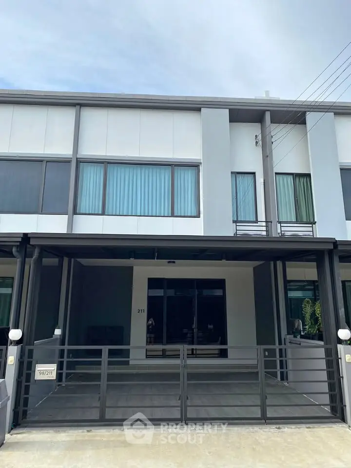 Modern townhouse exterior with sleek design and spacious parking area.
