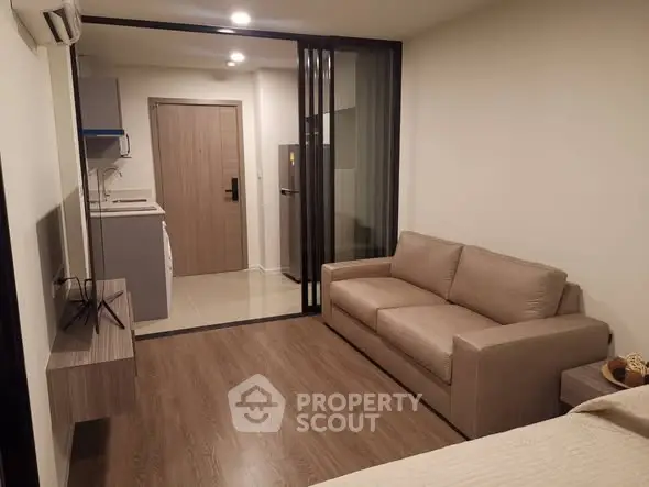 Modern studio apartment with cozy living area and compact kitchen.