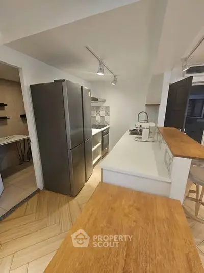 Modern kitchen with sleek appliances and wooden countertops in a stylish home.
