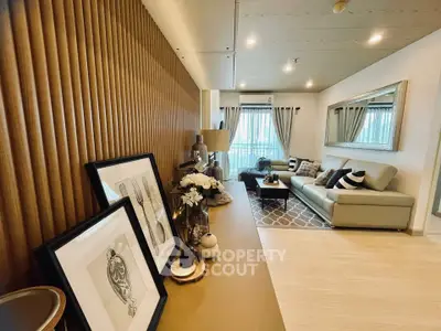 Stylish modern living room with elegant decor and large mirror enhancing space.
