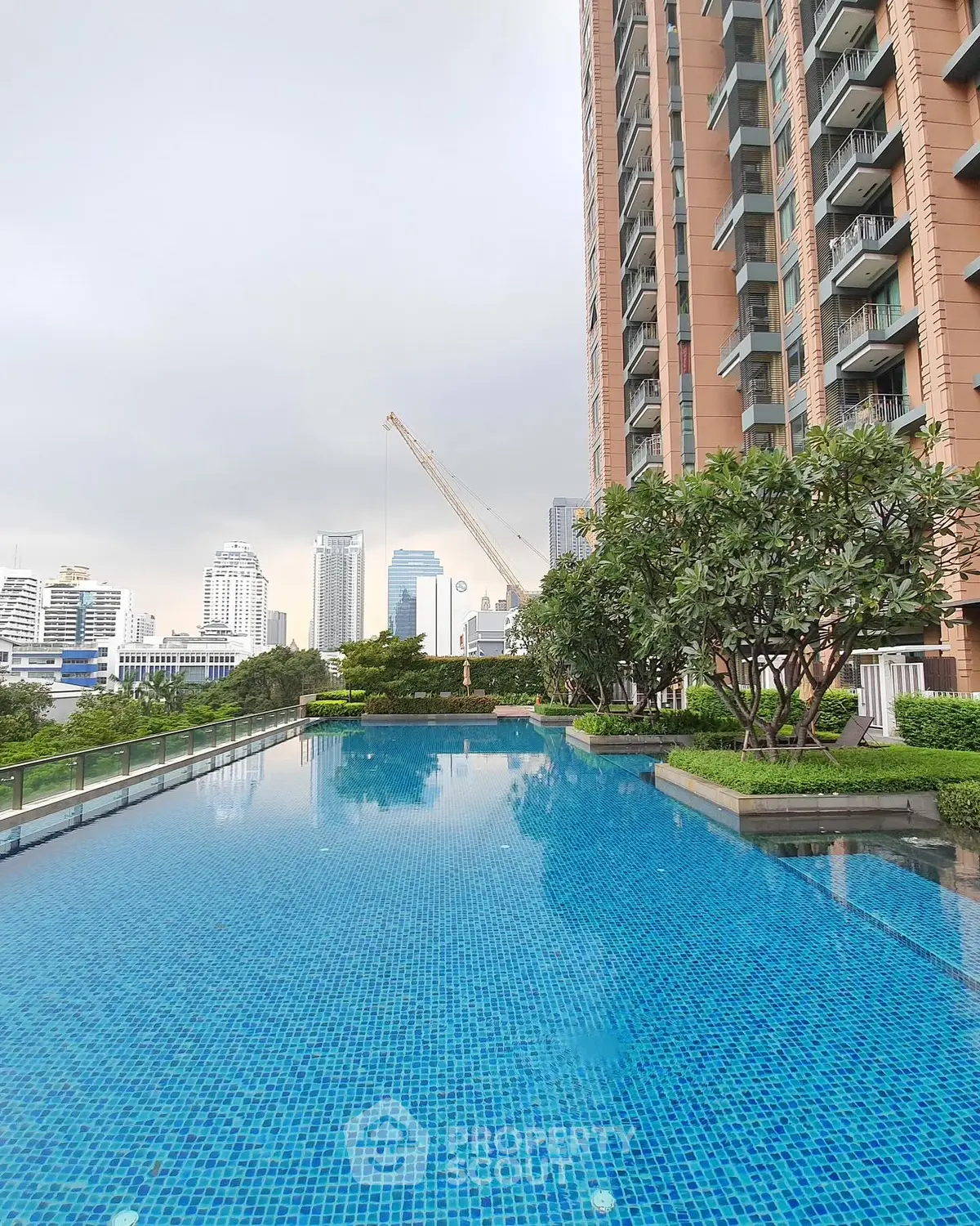 Luxurious high-rise building with stunning pool and cityscape view.
