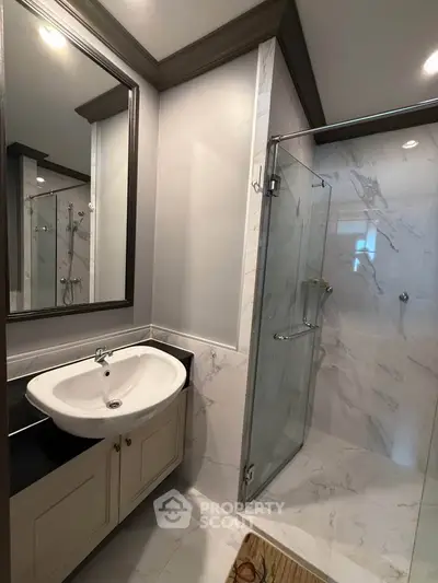 Modern bathroom with elegant marble tiles and glass shower enclosure