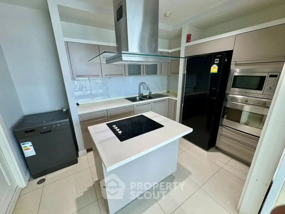 Modern kitchen with island, sleek appliances, and ample storage in a stylish apartment.