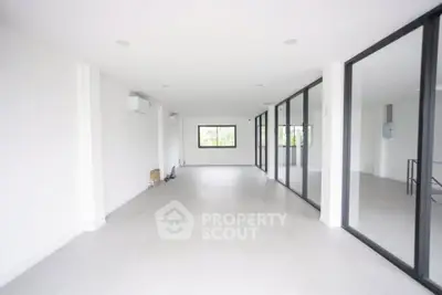 Spacious open-plan living area with large windows and modern design.