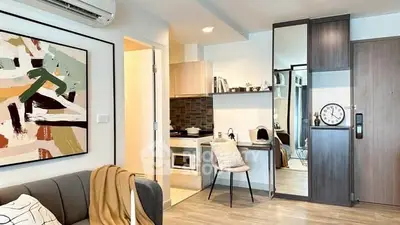 Modern studio apartment with stylish decor and compact kitchen area.