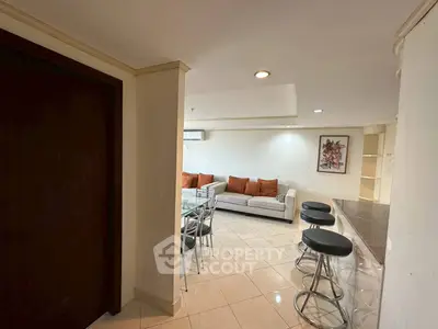 Spacious living room with modern furniture and bar seating in elegant apartment.