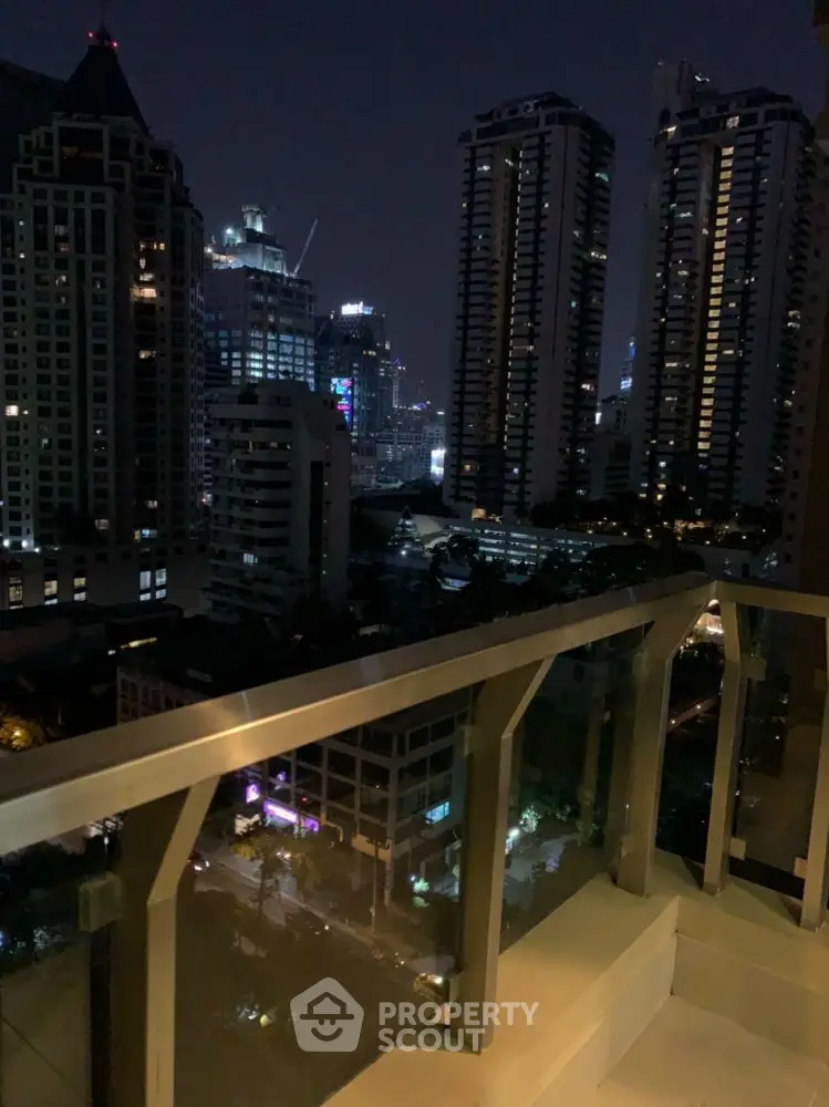 Stunning nighttime city view from high-rise balcony with modern railing
