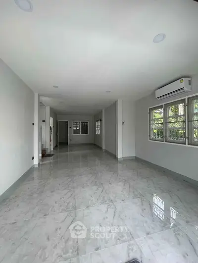 Spacious empty living room with marble flooring and large windows