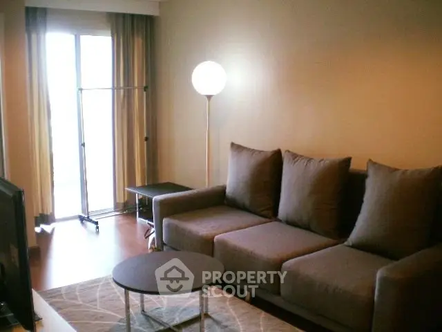 Cozy living room with modern sofa and floor lamp, perfect for relaxation.
