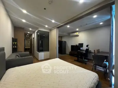 Spacious modern studio with cozy bedroom and study area, featuring sleek design and ample lighting.