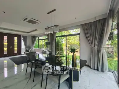 Luxurious open-plan living and dining area with large windows and elegant decor.