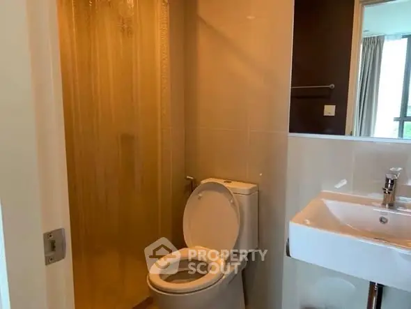 Modern bathroom with glass shower and sleek fixtures in a contemporary apartment.