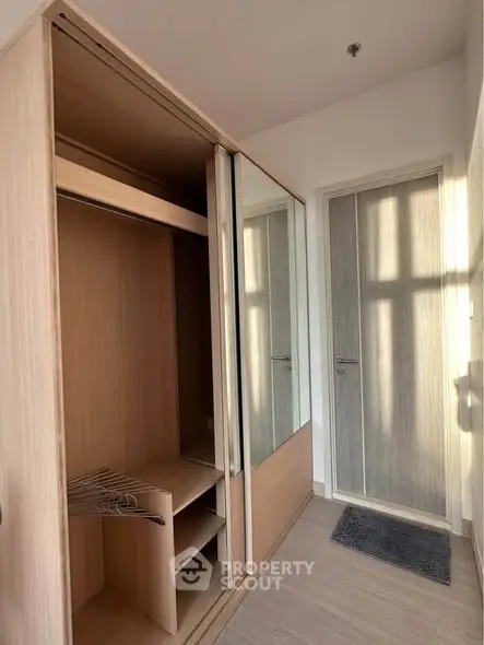 Modern storage space with sliding mirrored doors and wooden finish