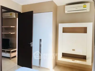 Modern bedroom with built-in wardrobe and air conditioning unit, featuring sleek design and ample natural light.