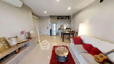 Modern living room with cozy sofa, stylish decor, and open kitchen layout.