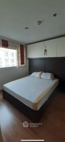 Cozy bedroom with natural light and modern furnishings in a stylish apartment.