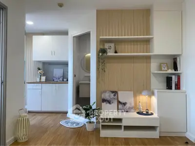 Modern living room with stylish decor and wooden flooring, featuring built-in shelves and cozy lighting.