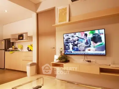 Modern living room with wall-mounted TV and stylish kitchen area