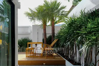 Charming tropical balcony with lush greenery and cozy seating area