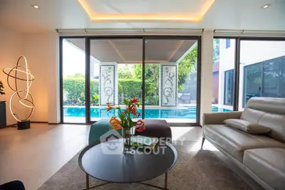 Luxurious living room with pool view, modern decor, and elegant lighting in a contemporary home.