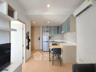 Modern open-layout kitchen with sleek cabinets and dining area in a cozy apartment.