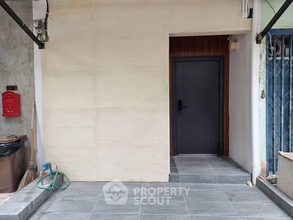 Modern entrance with sleek black door and tiled flooring