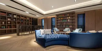 Luxurious living room with modern blue sofas and elegant wooden bookshelves, perfect for relaxation and entertainment.