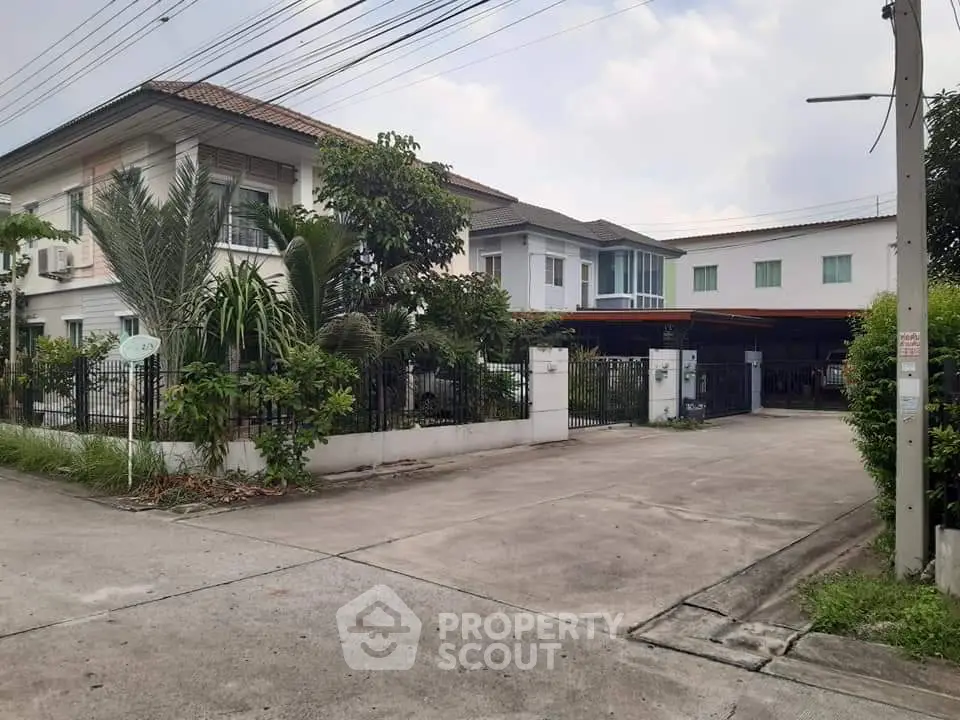 Spacious suburban house with lush greenery and ample driveway space.