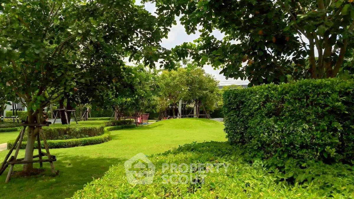 Lush green garden with manicured lawns and mature trees in a serene residential setting.
