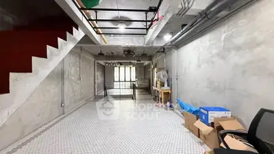 Spacious industrial-style basement with modern lighting and ample storage space.