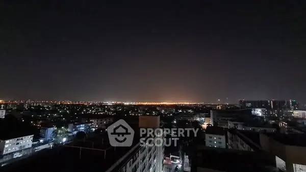 Stunning cityscape night view with illuminated skyline and distant horizon lights.