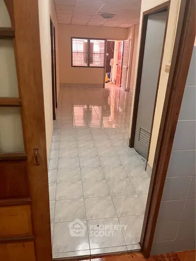 Spacious hallway with tiled flooring and natural light in a residential property.