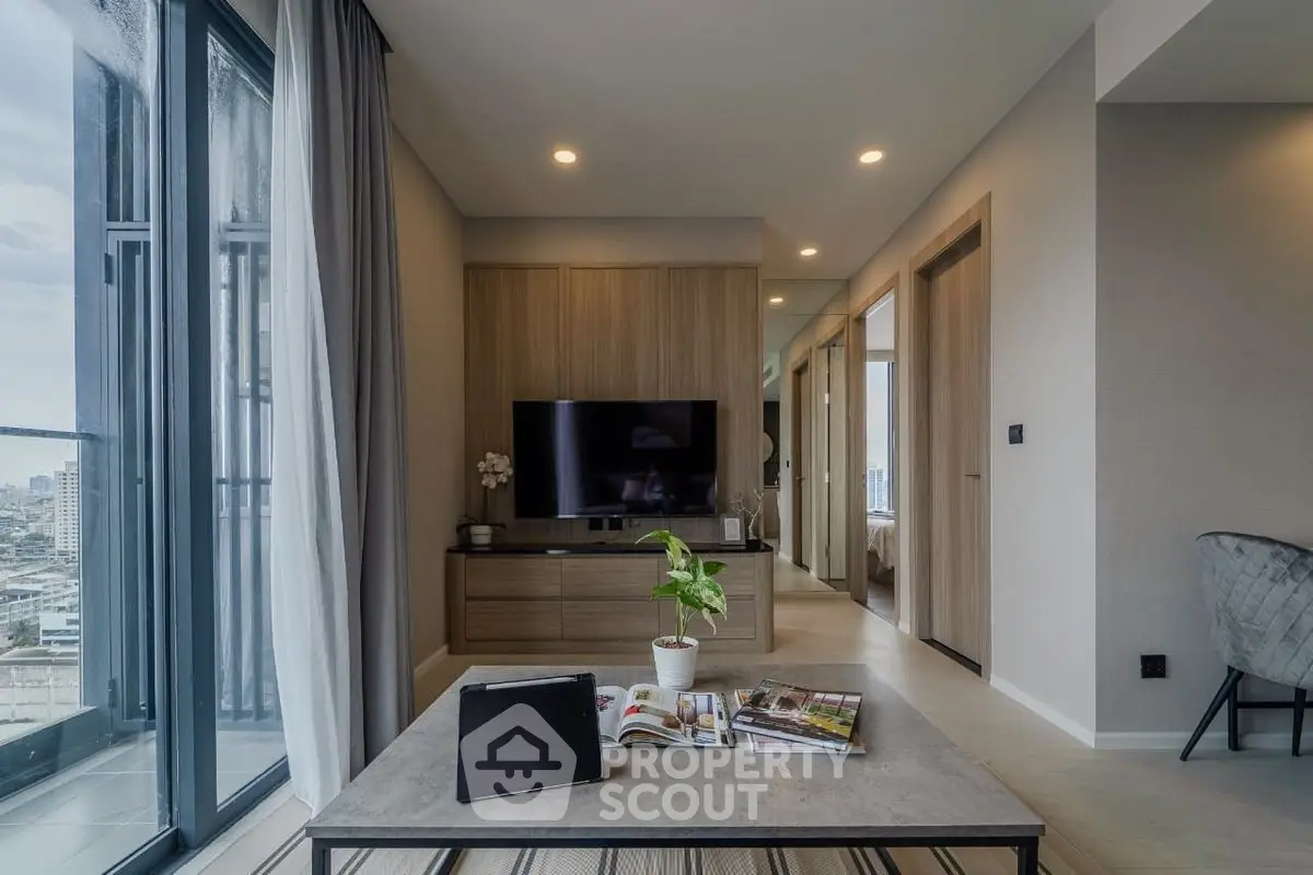 Modern living room with city view, sleek furniture, and stylish decor in a high-rise apartment.