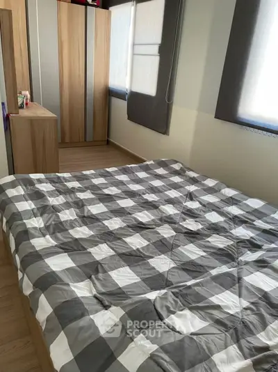 Cozy bedroom with checkered bedding and ample natural light