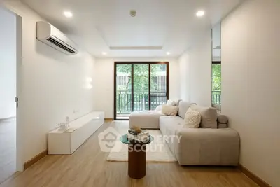 Spacious modern living room with large windows and cozy seating area.