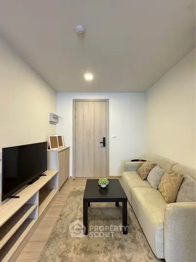 Modern living room with cozy sofa and flat-screen TV, perfect for relaxation.