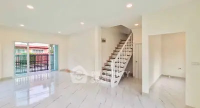 Spacious modern living room with elegant staircase and large windows