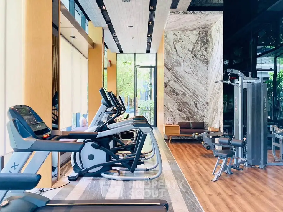 Luxurious gym with modern equipment and elegant design in upscale residential building.